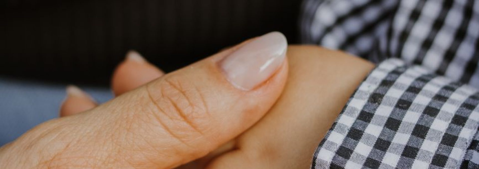 adult hand holding child s hand in comforting gesture